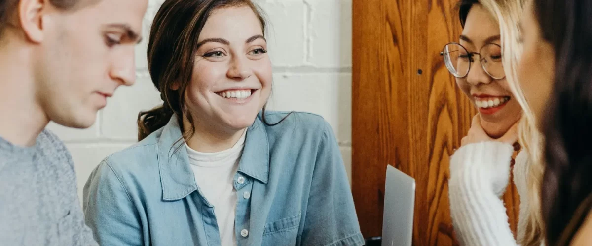 Work colleagues talking at a table and smiling